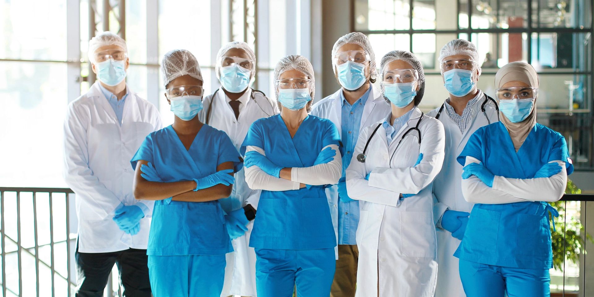 Equipe de saúde uniformizada, com scrubs, jalecos e toucas